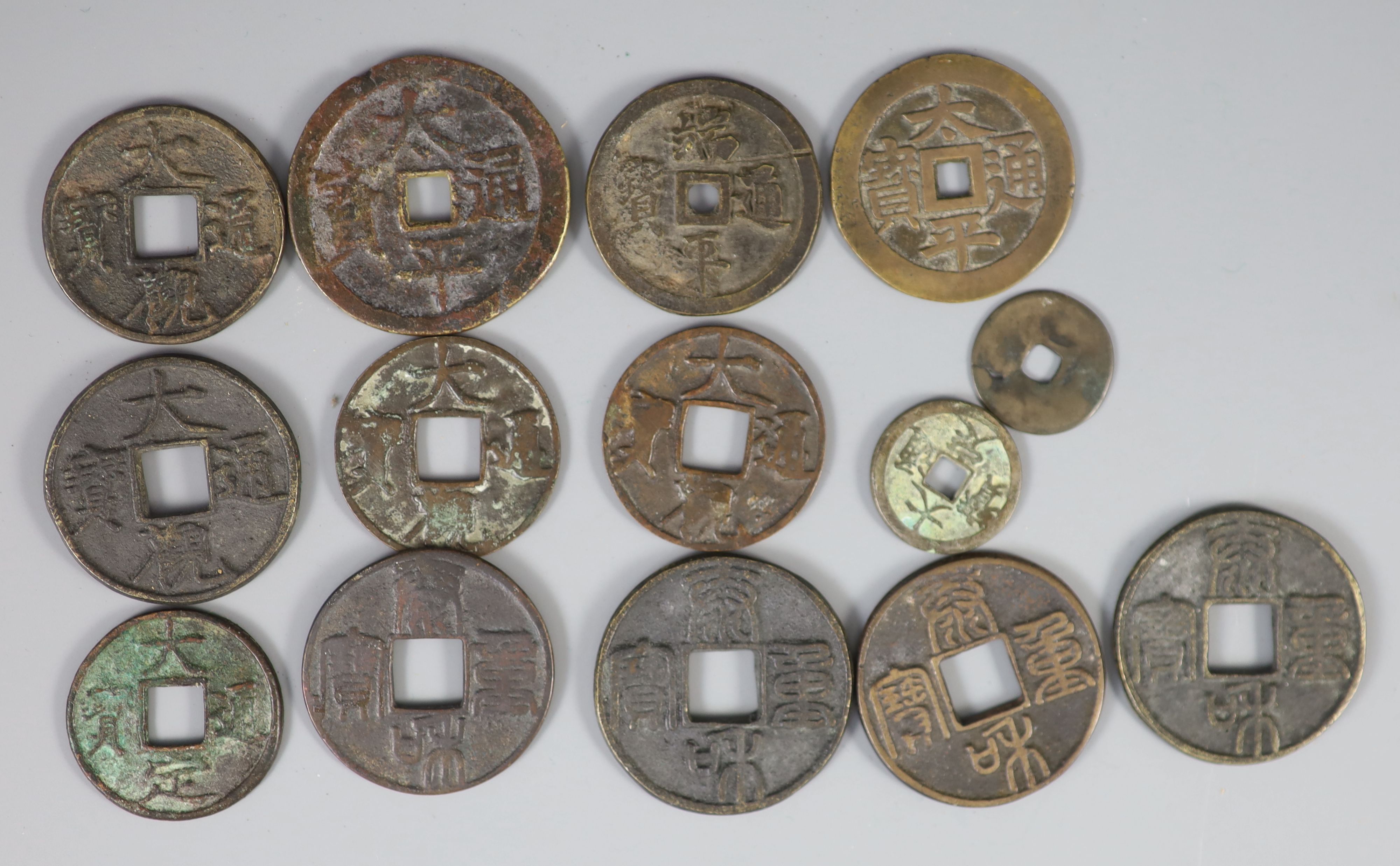 China, a group of 14 bronze coin charms or amulets, Qing dynasty,